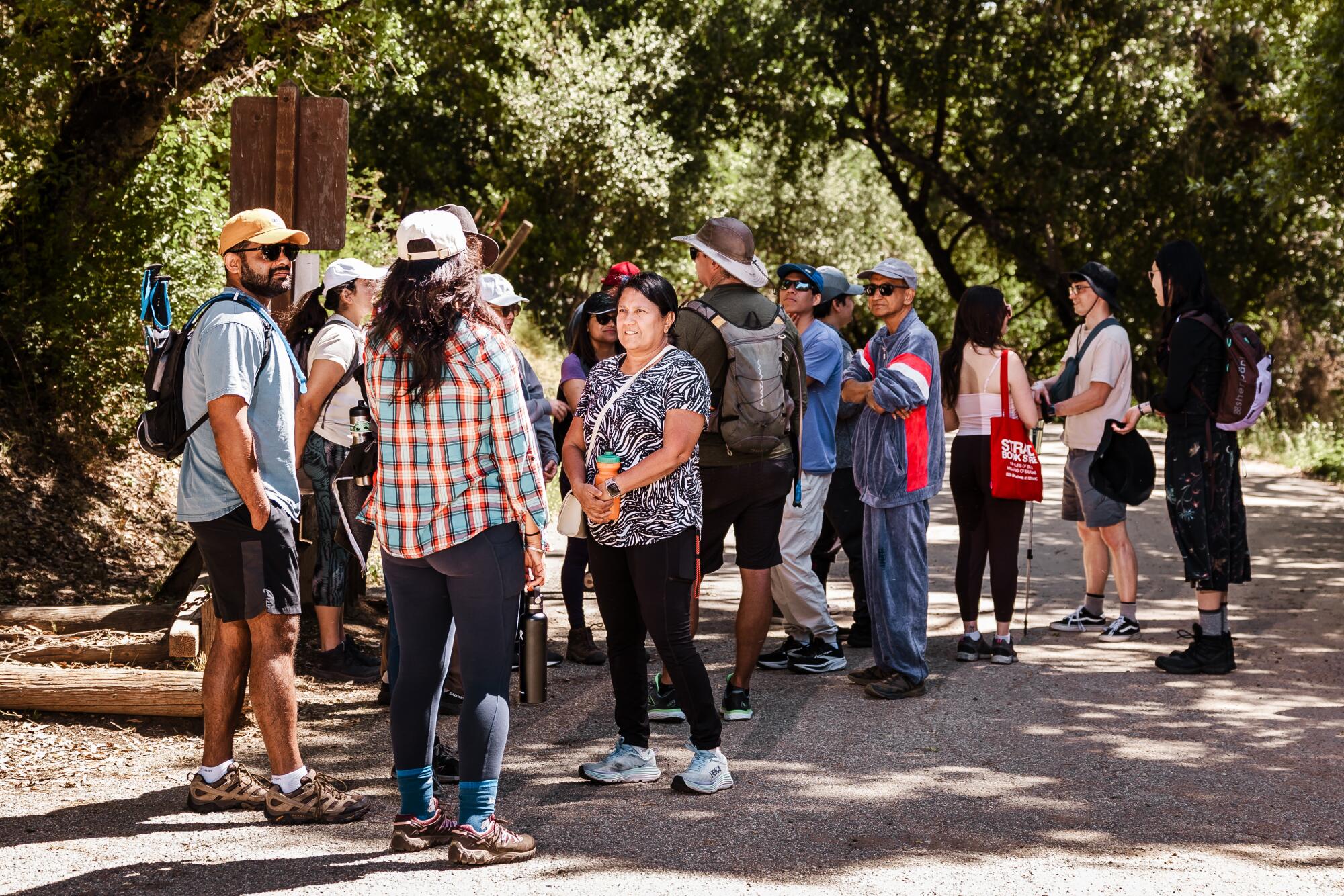 Hhikers gather and chat with one another at the trailhead.
