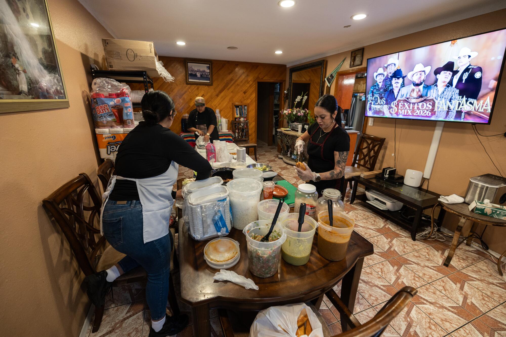 People prepare food and salsas in a dining room.