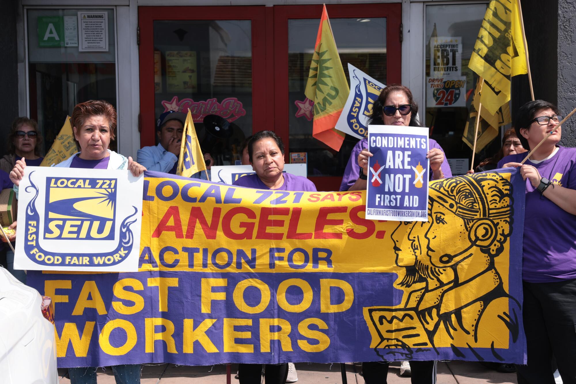 Members of Service Employees International Union Local 721 protest in support of workers outside a Carl's Jr.