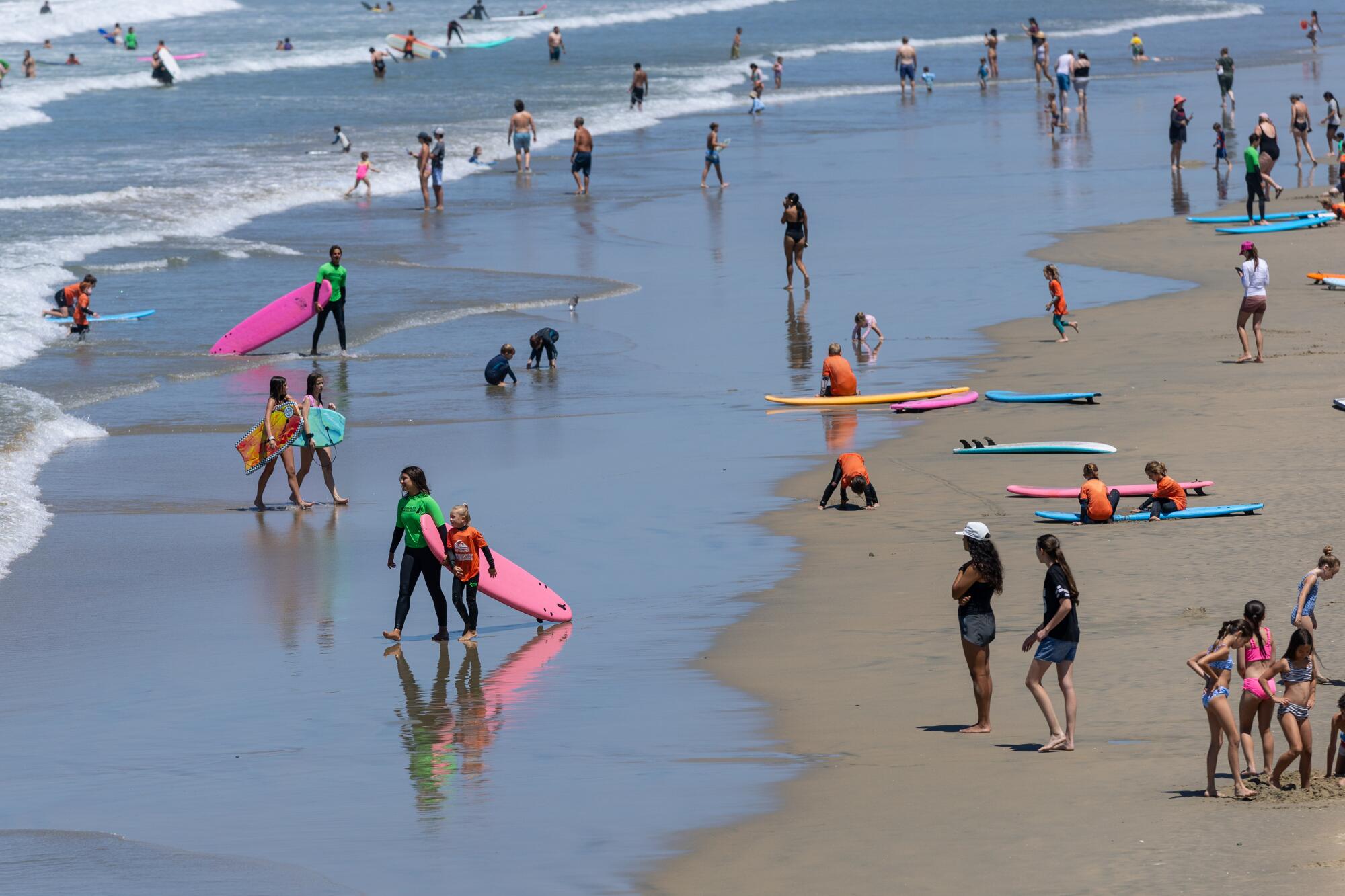Beachgoers enjoy at day on the sand at Newport Beach on July 7.