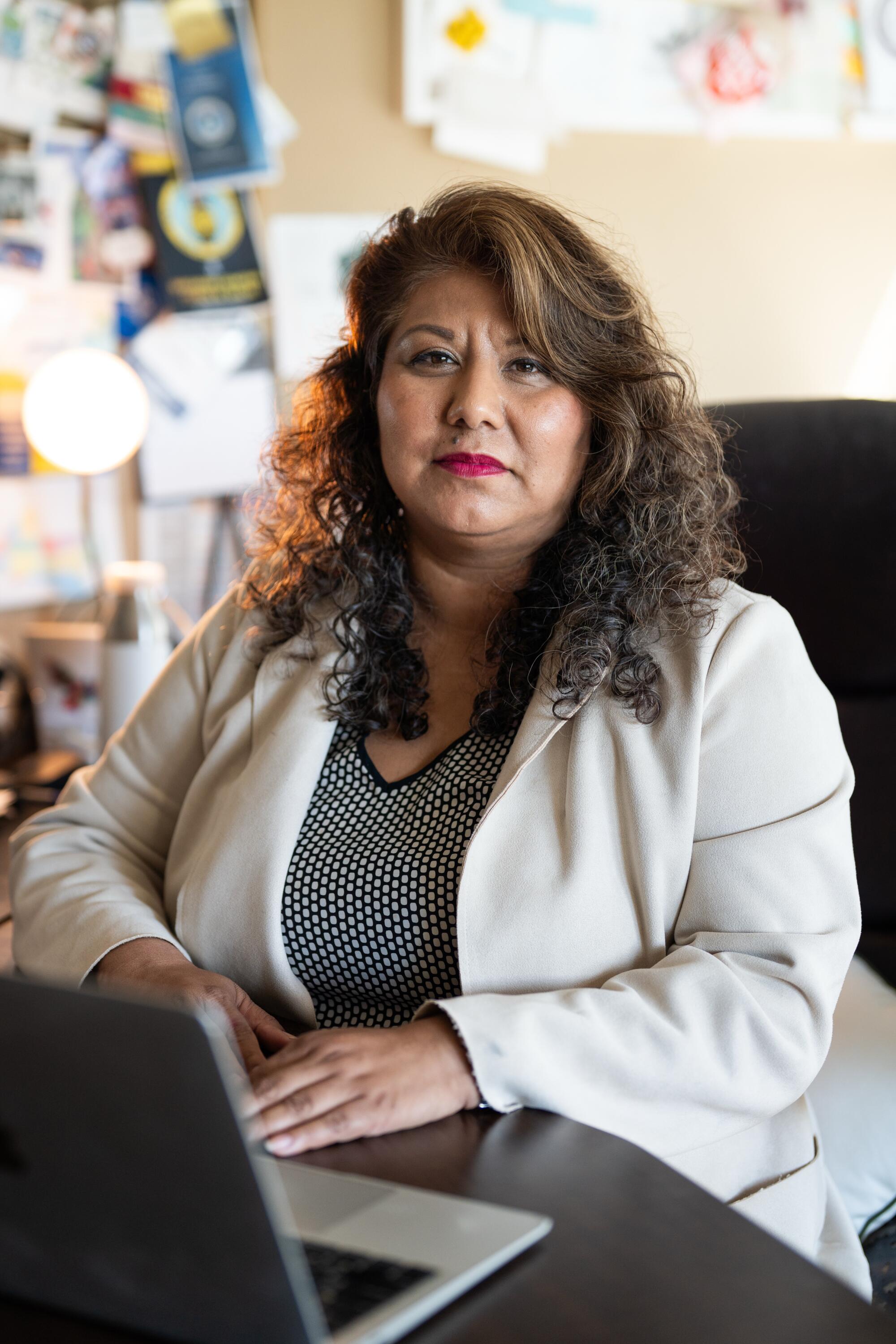 Mayor Alma Hernadez sitting at an office desk with an open laptop