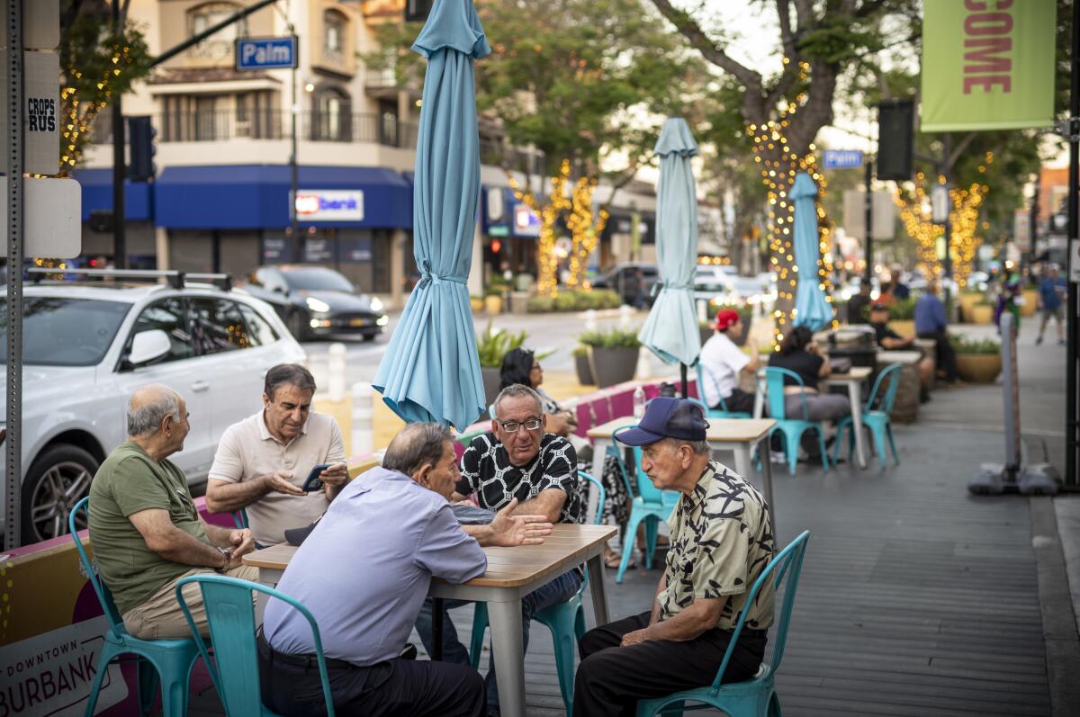 A group of men sitting at a table, talking to each other