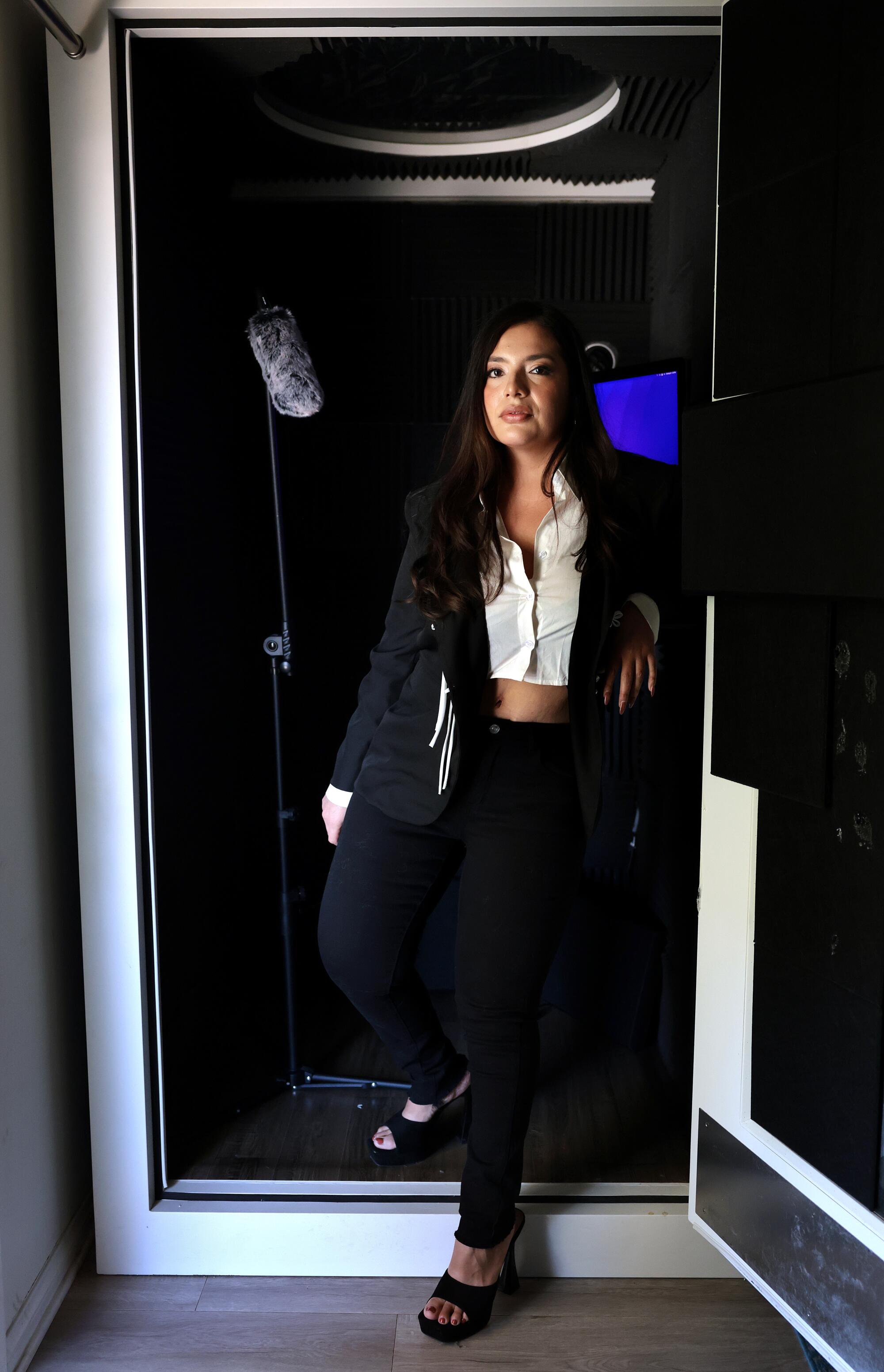 Stacy Rivera standing with one foot outside a recording booth