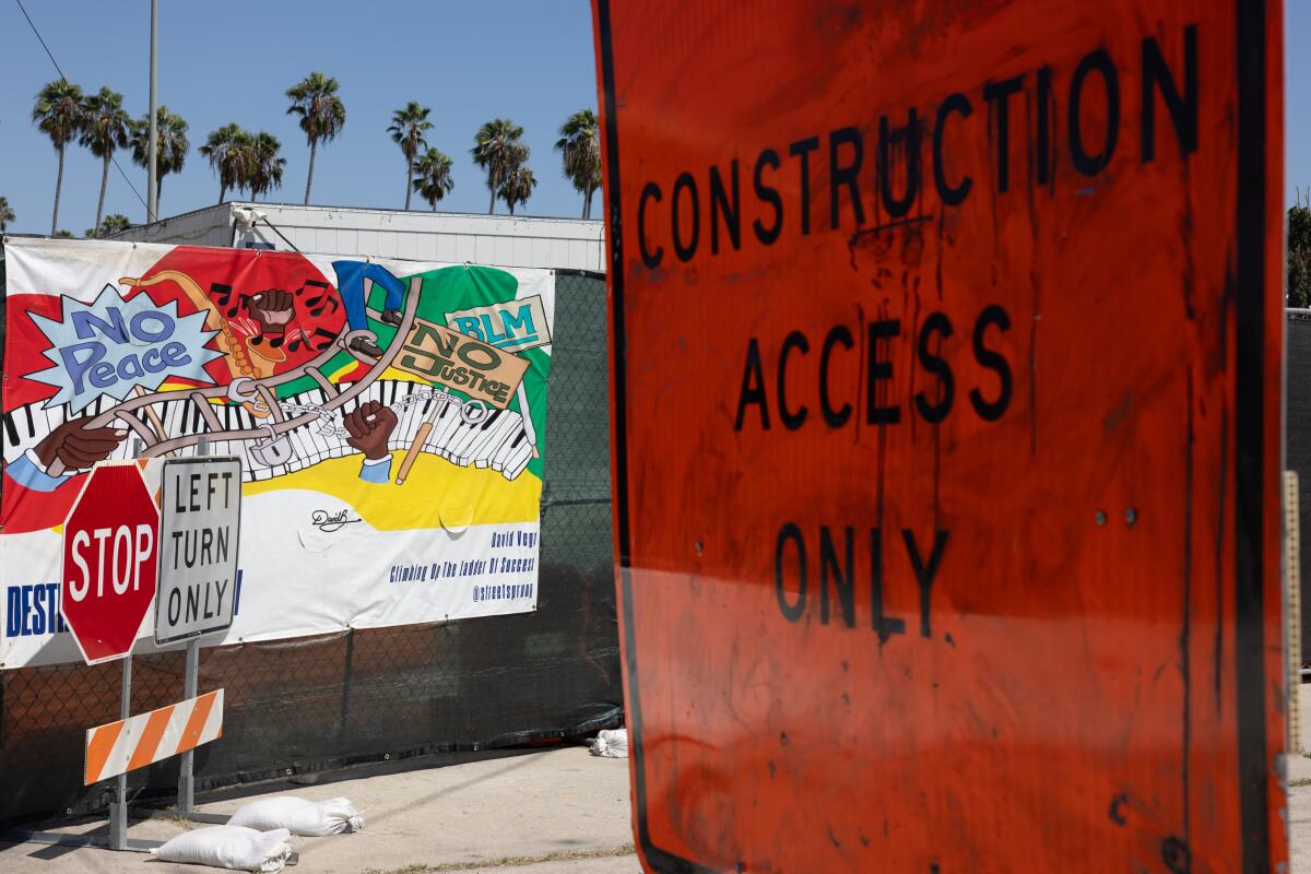 Construction signs and a community mini-mural banner