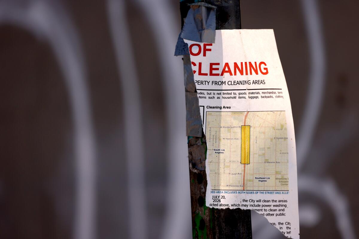 A torn notice announcing a clean-up of homeless encampments hangs from a stop sign on Grand Avenue at 51st Street. 