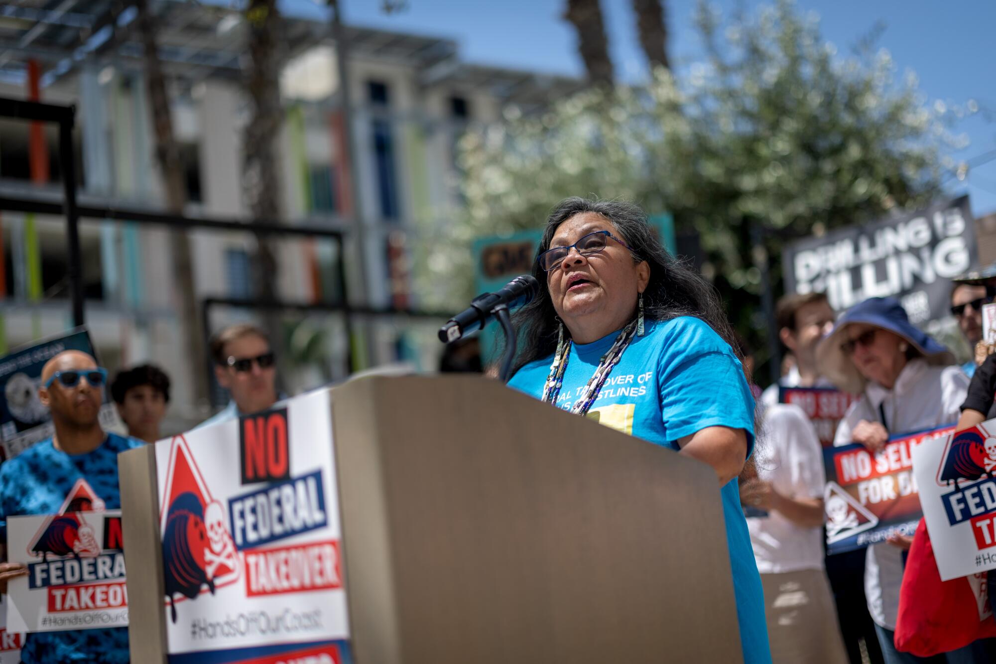A woman speaks at a microphone during a rally. 