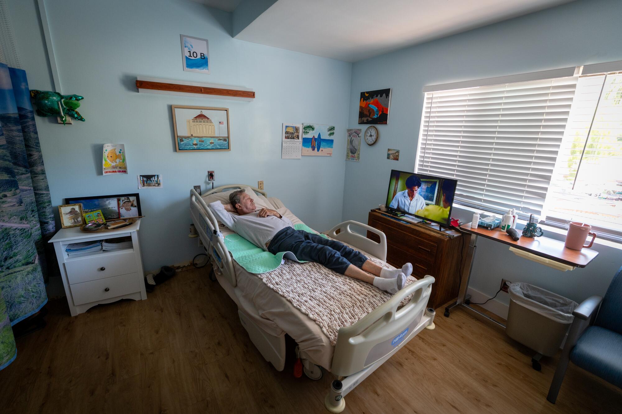 Long-term patient Bob Humphries, a former surfboard shaper from Costa Mesa, watches TV in his room at Catalina Island Health.