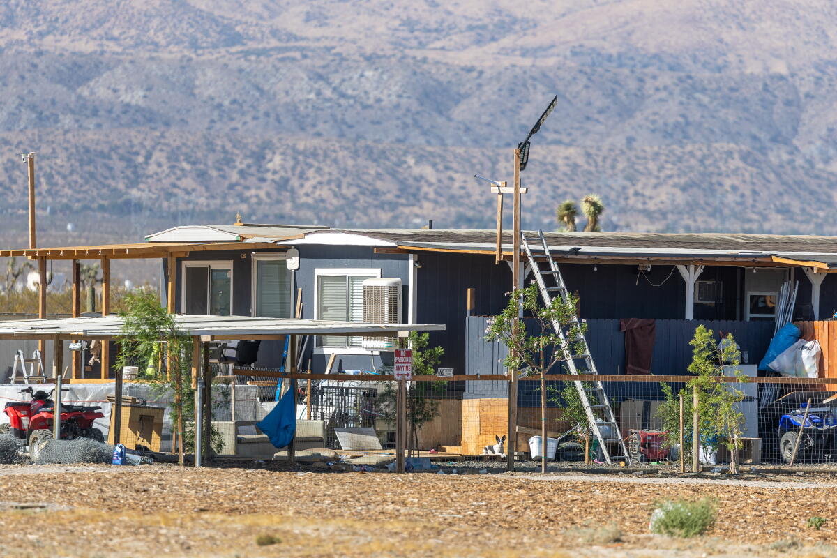 Mobile homes in a fenced area with young trees