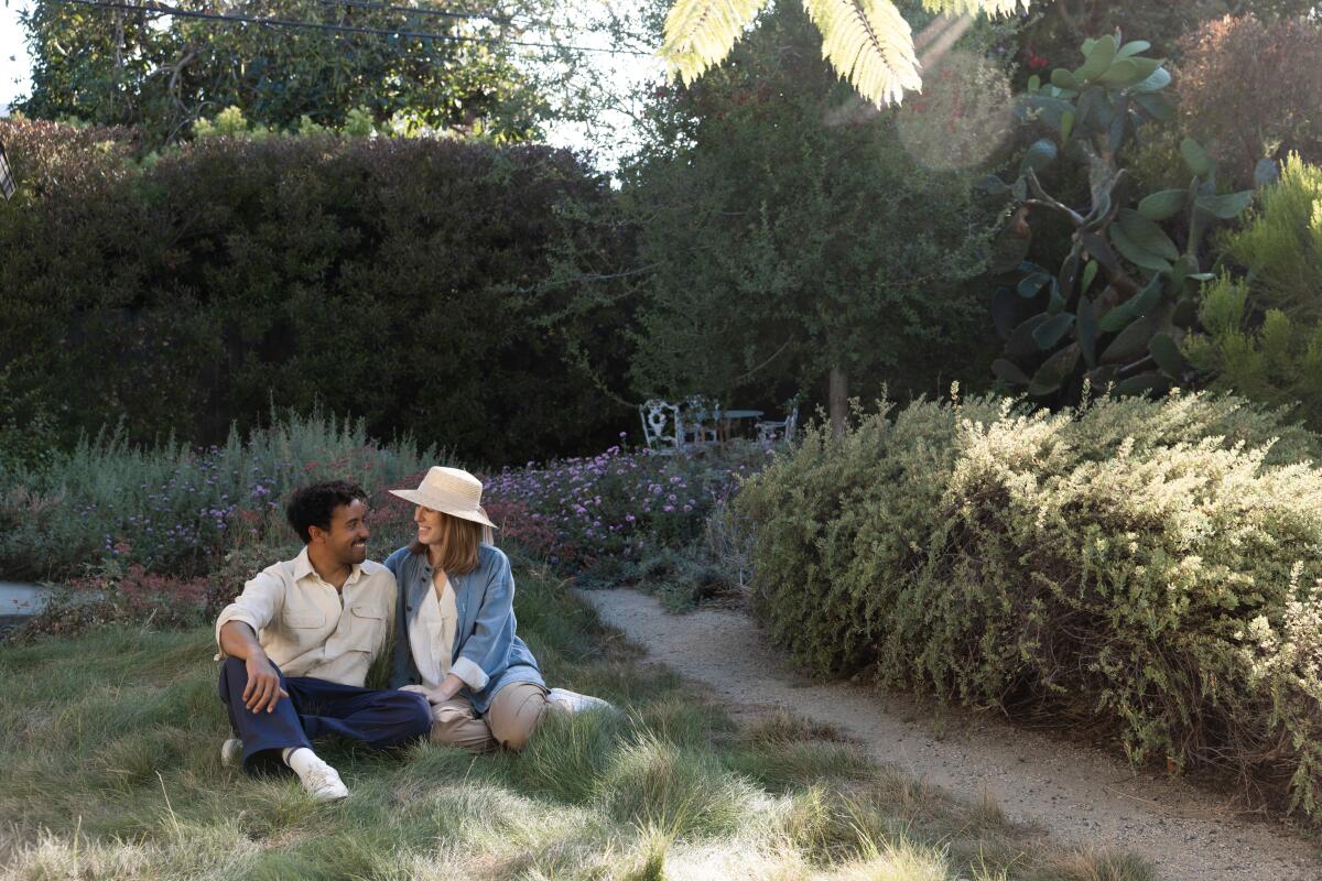 Phoebe Novack and Brian Auggrey pose for a portrait in the backyard of their home