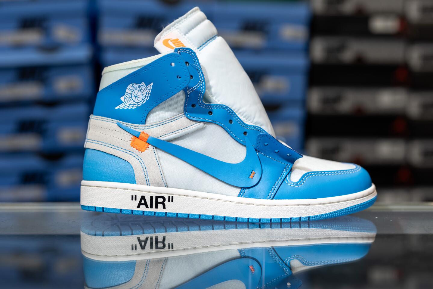 A side view of a white and blue high-top shoe with a blue swoosh