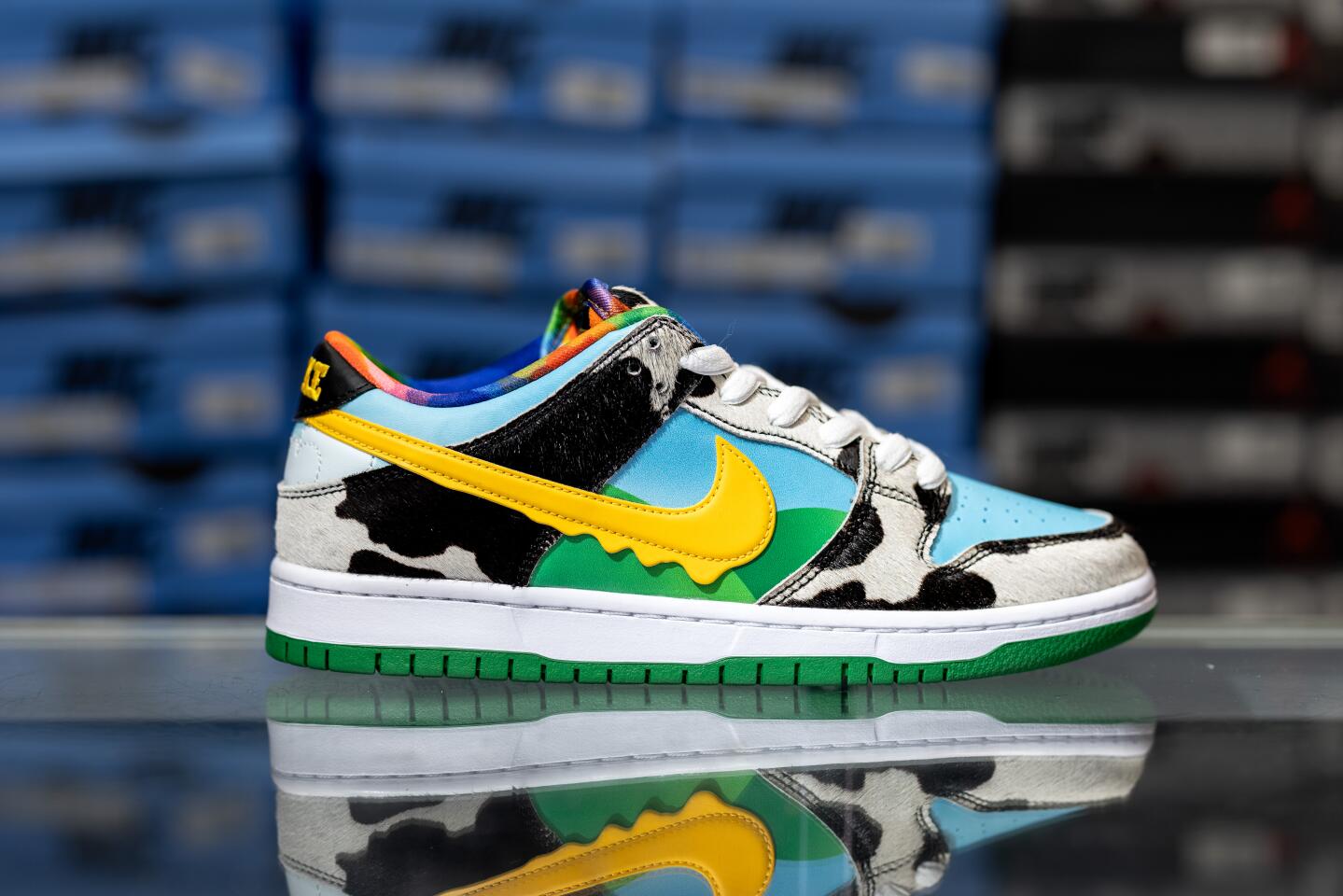 A side view of a shoe that has black, blue, yellow and green colors.