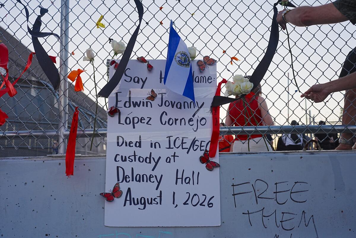 A sign made by pro-immigrant activists hangs on a fence as they gather outside Delaney Hall Detention Facility