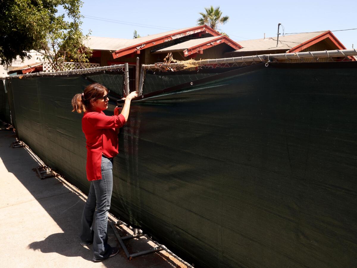 JoAnn Koplin looks over a home that is being remodeled that rests behind a screen in Hollywood.