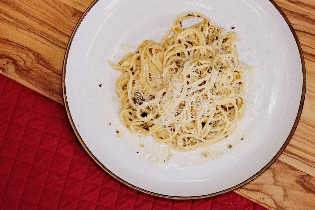 A plate of spaghetti al limone on wood and red fabric in the L.A. Times Test Kitchen.