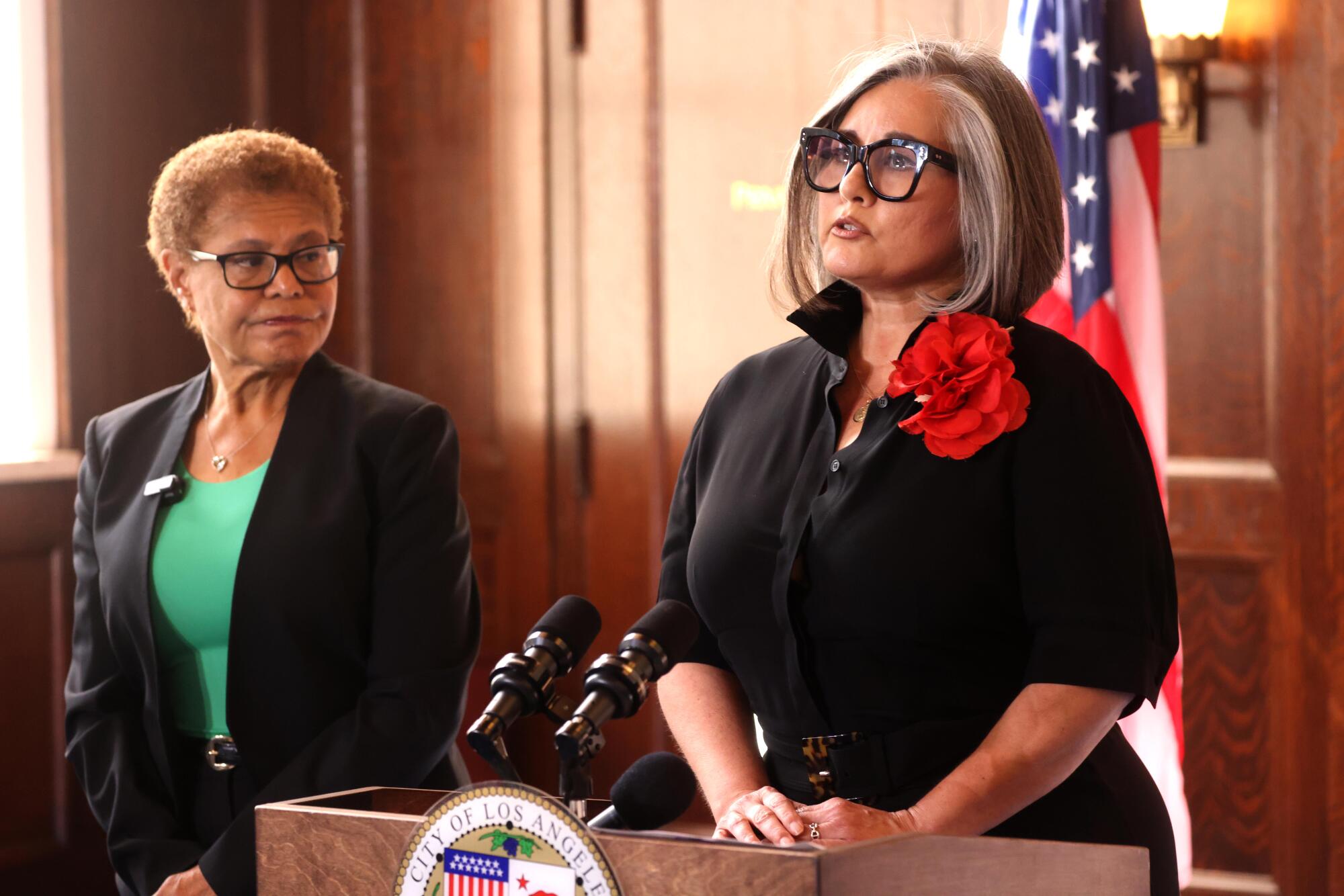 Mayor Karen Bass, left, looks on as Los Angeles City Council member Monica Rodriguez speaks.
