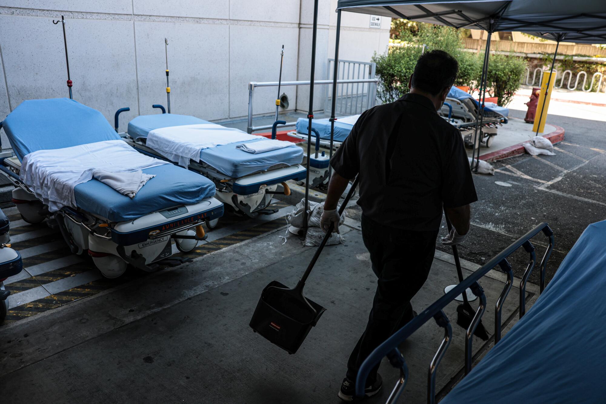 Beds are stored outside a tent used for emergency room intake and triage at Martin Luther King Jr. Memorial Hospital.