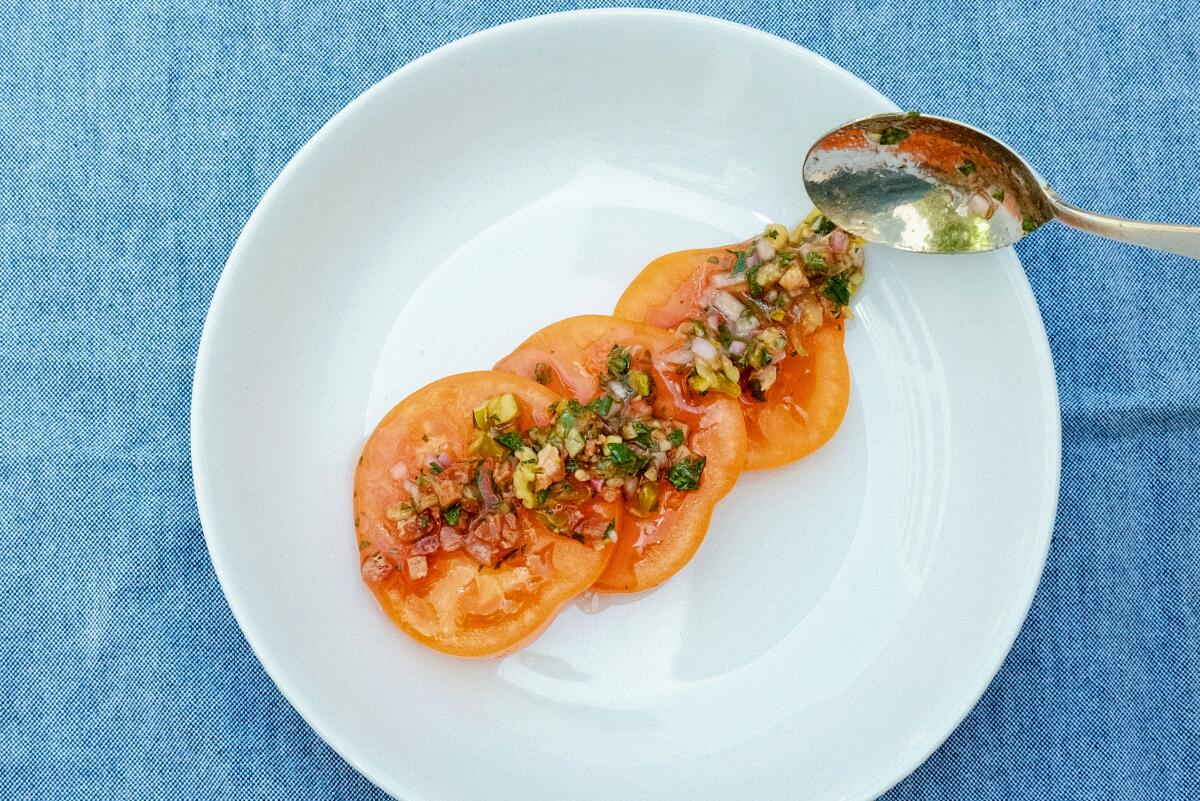 A chunky dressing atop a few tomato slices. 
