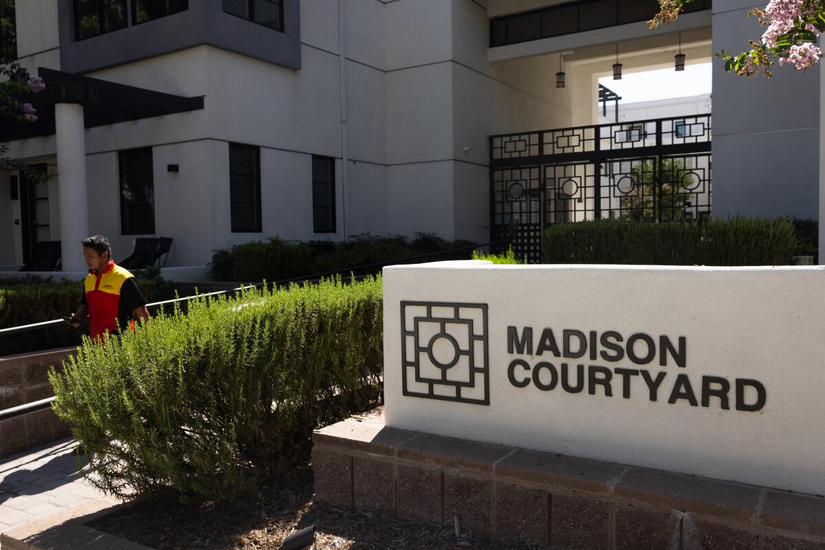 A building with a sign in front that says "Madison Courtyard."