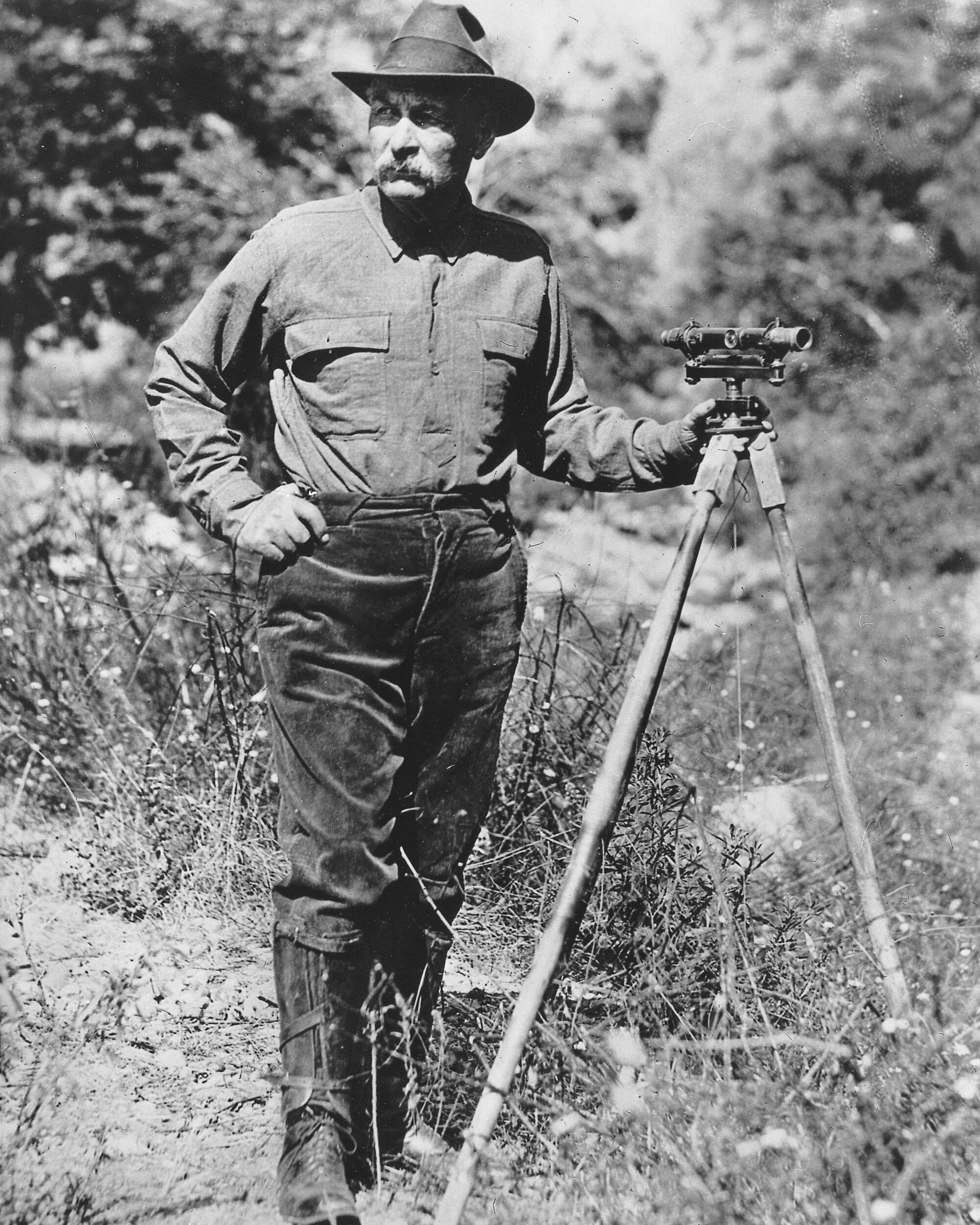 A black and white surveyor in a meadow