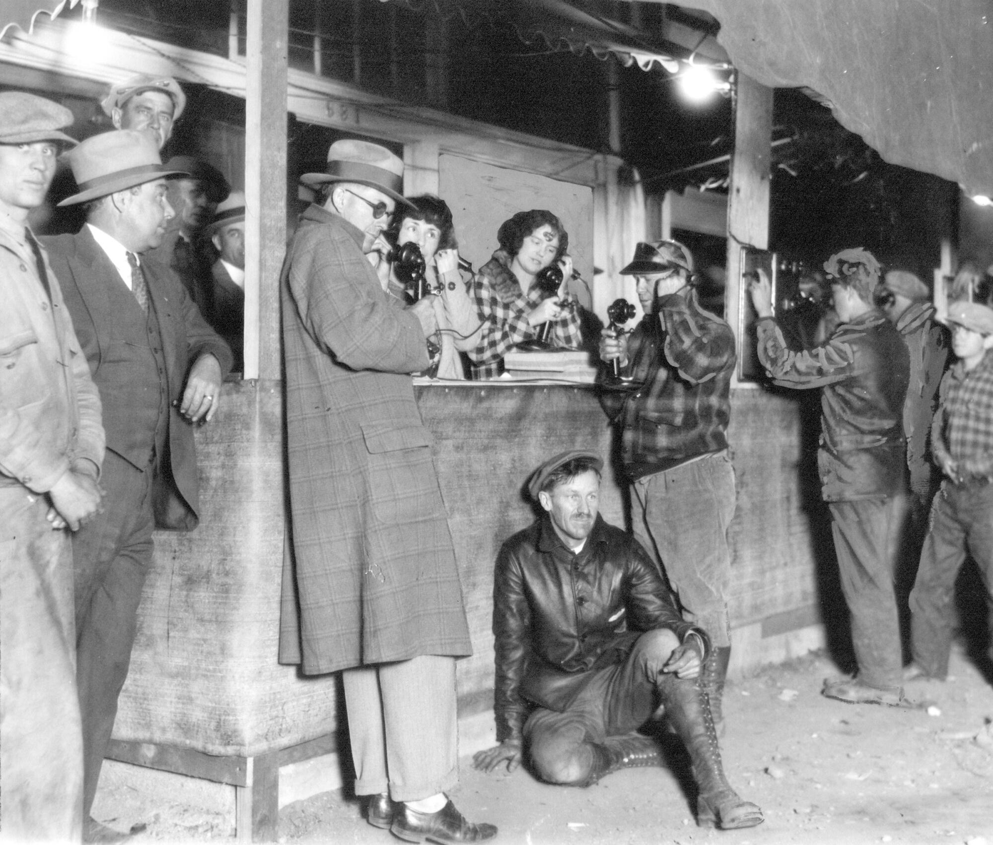 At an emergency telephone station, people seek information after the dam's collapse.