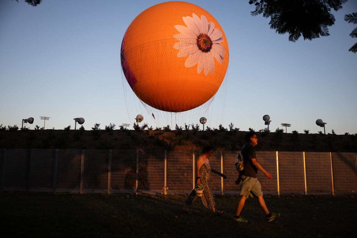 Festivalgoers walk past the Great Park Balloon during Daisy Chain Fields at the Great Park in Irvine