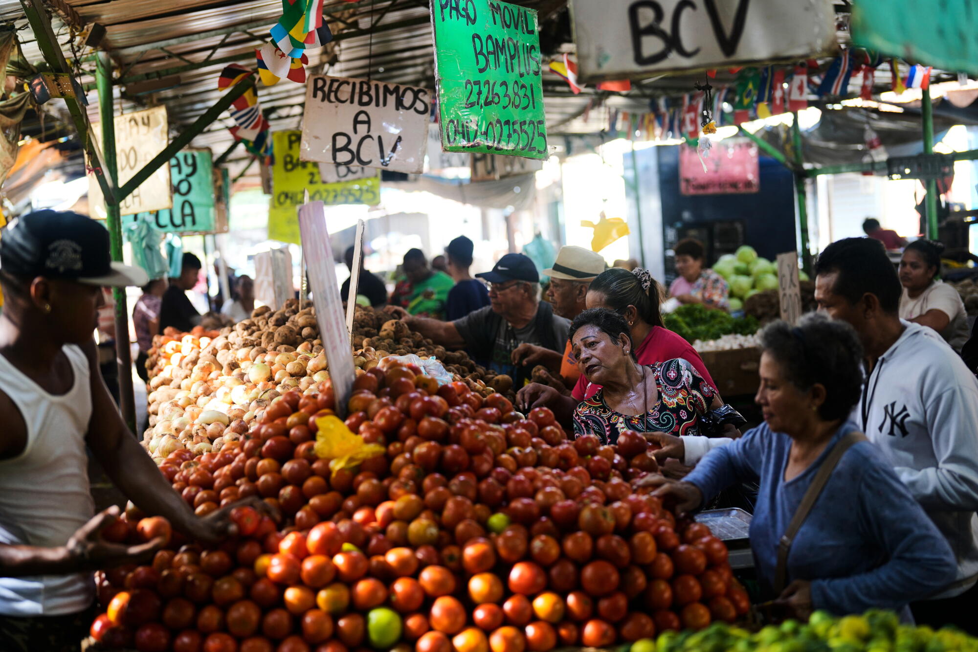 People shop for produce at a market in Maracaibo, the heart of Venezuela's oil industry. .