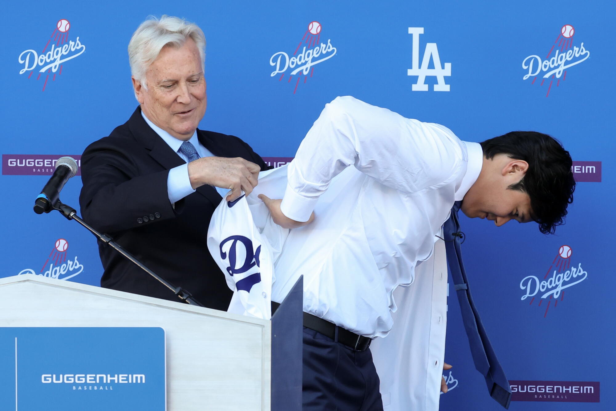 Dodgers owner Mark Walter helps Shohei Ohtani put on a jersey