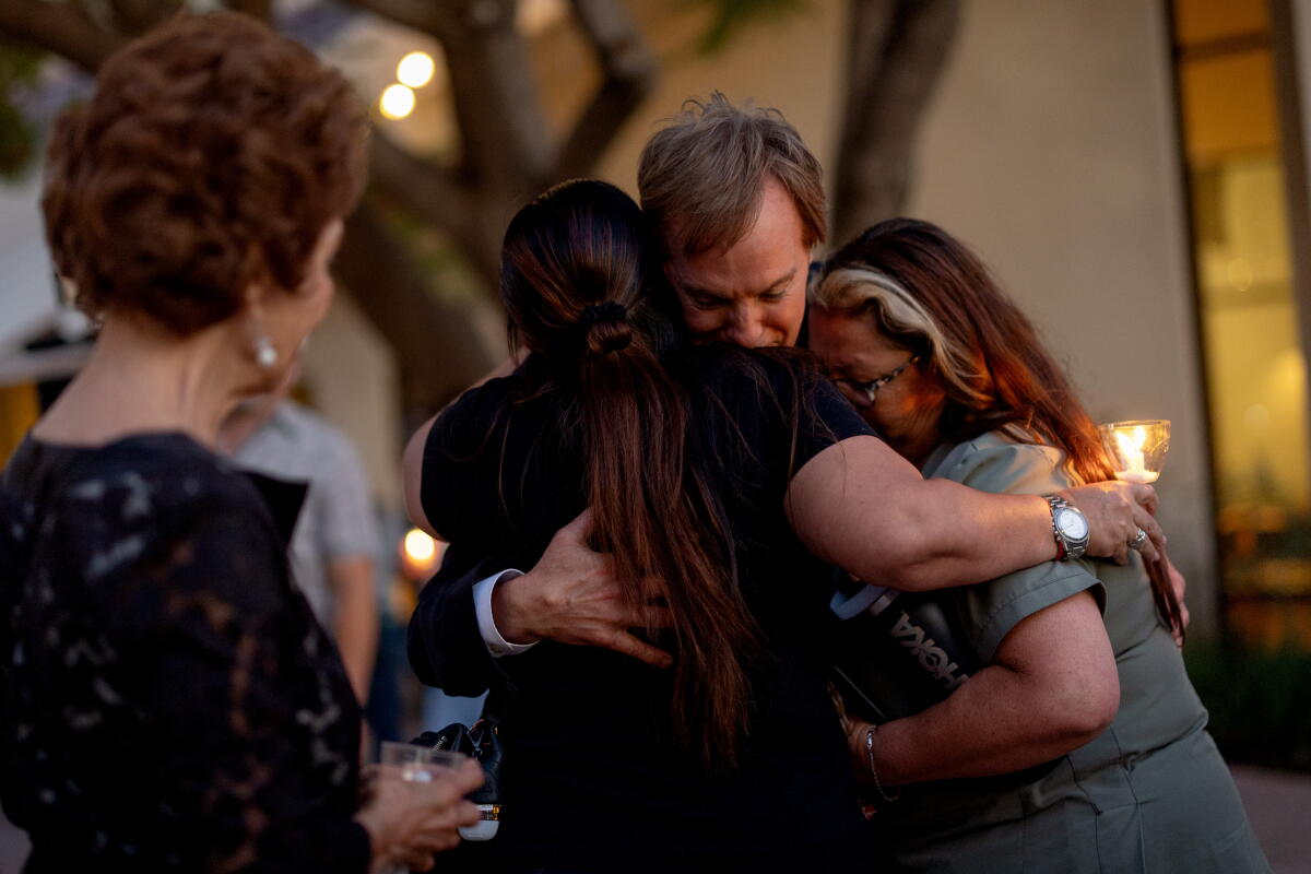 NBC news reporter Robert Kovacik embraces people at St. John Eudes Parish