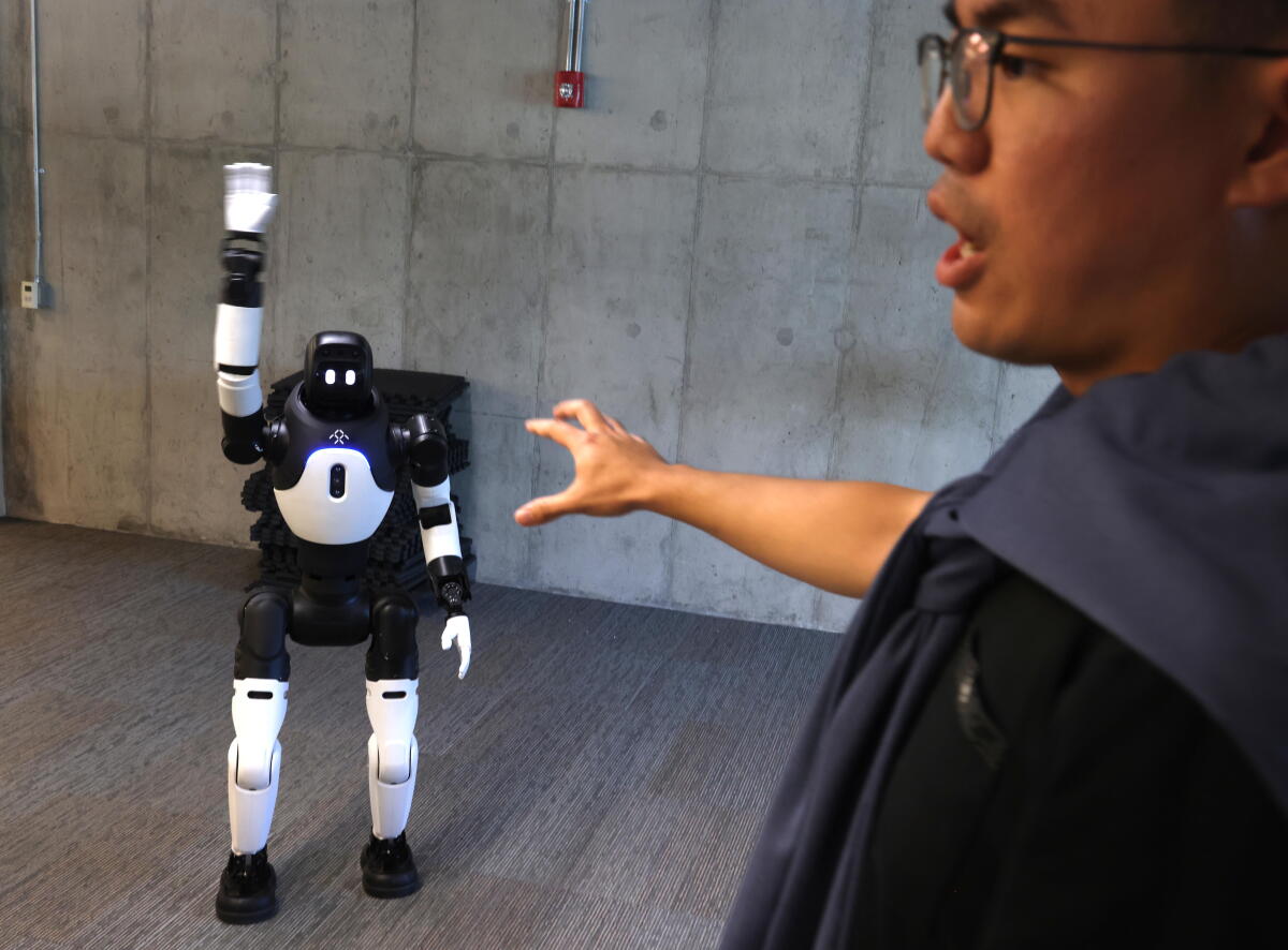 Di Wu, system lead at Faraday Future EAI Robotics, gives commands to a robot at Faraday Future in El Segundo.