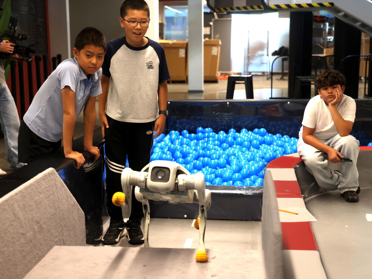 Students watch their programmed robot travel through an obstacle course during a robotics summer camp at Faraday Future.