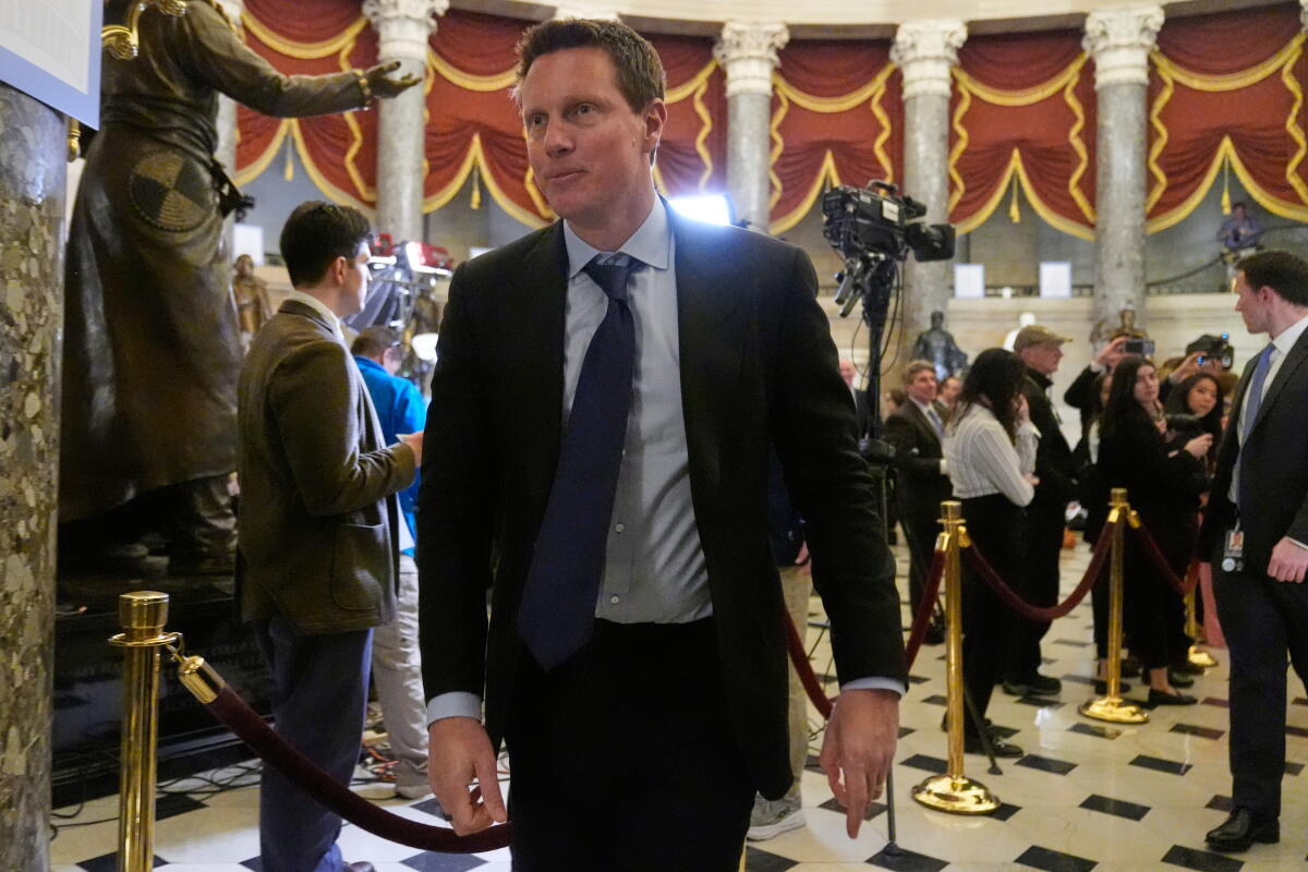 David Ellison walks in a business suit