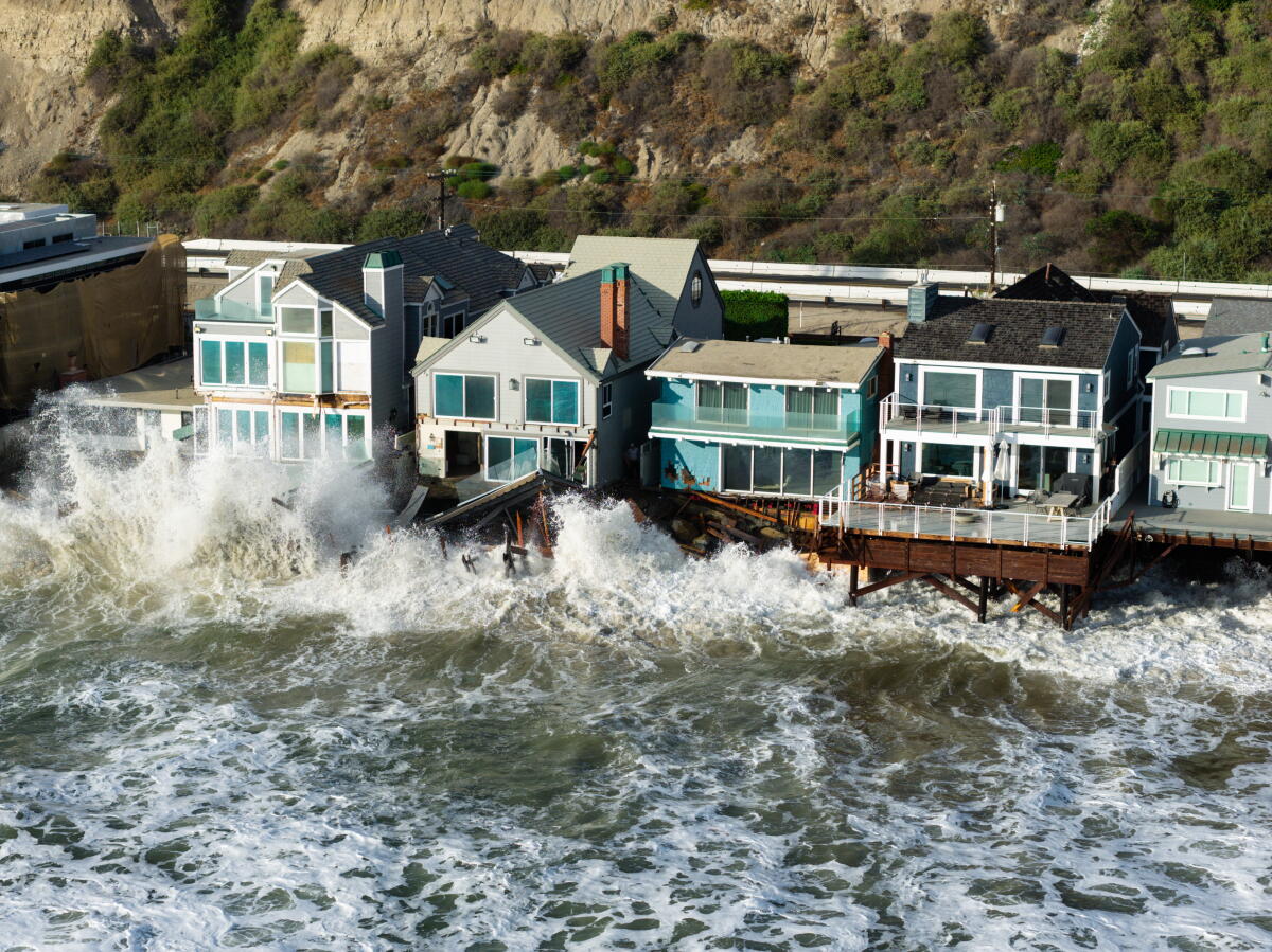 Waves inundate homes along Beach Road in Dana Point on Tuesday.
