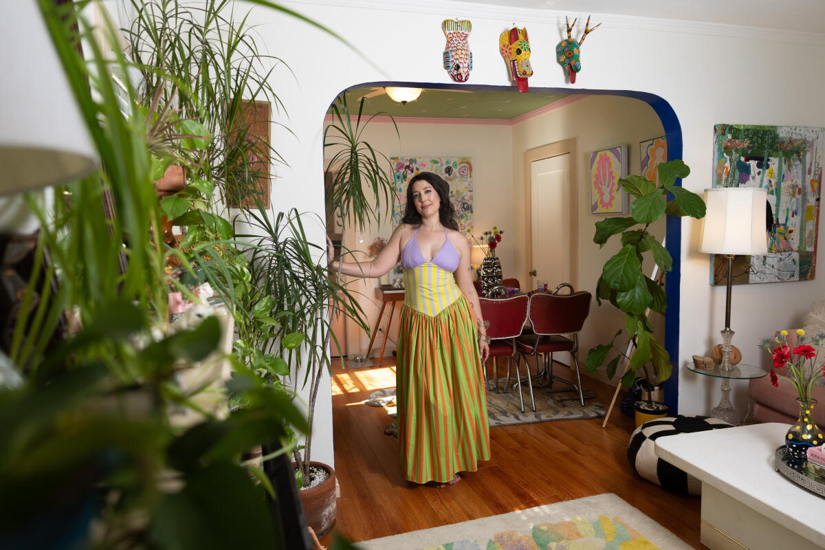 A woman poses for a portrait inside her home 