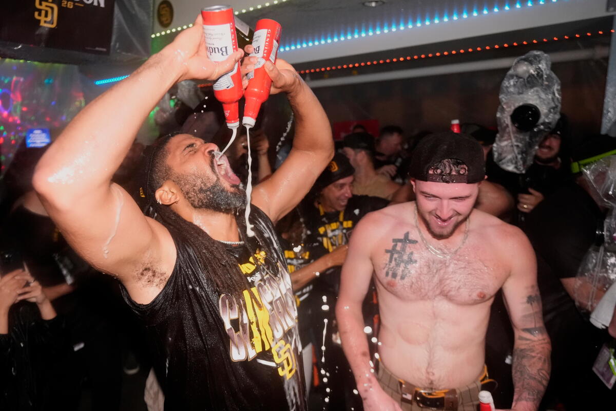 San Diego Padres' Fernando Tatis Jr., left, and Jackson Merrill, celebrate with teammates.