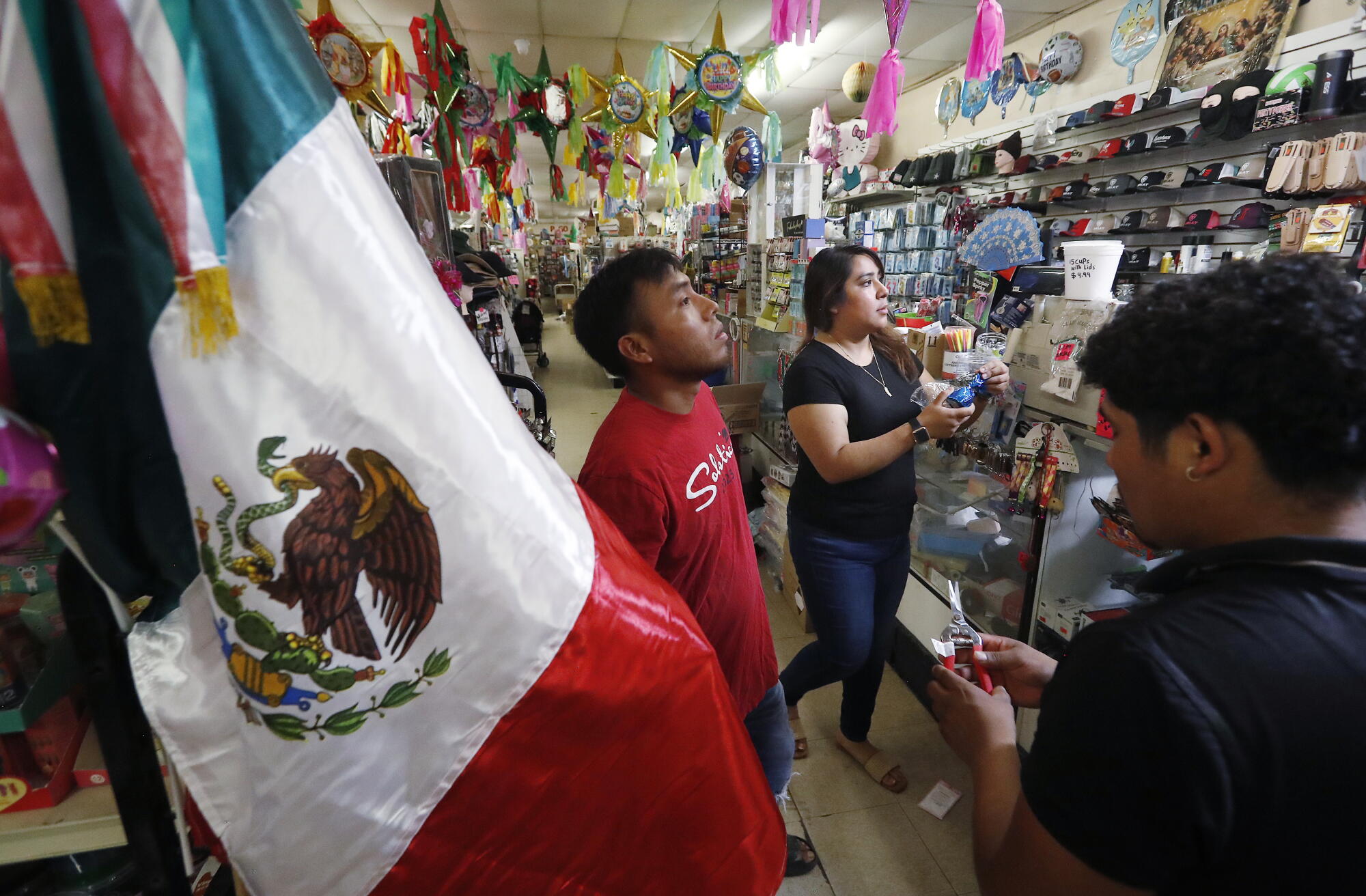 Shoppers stand at a discount store counter.